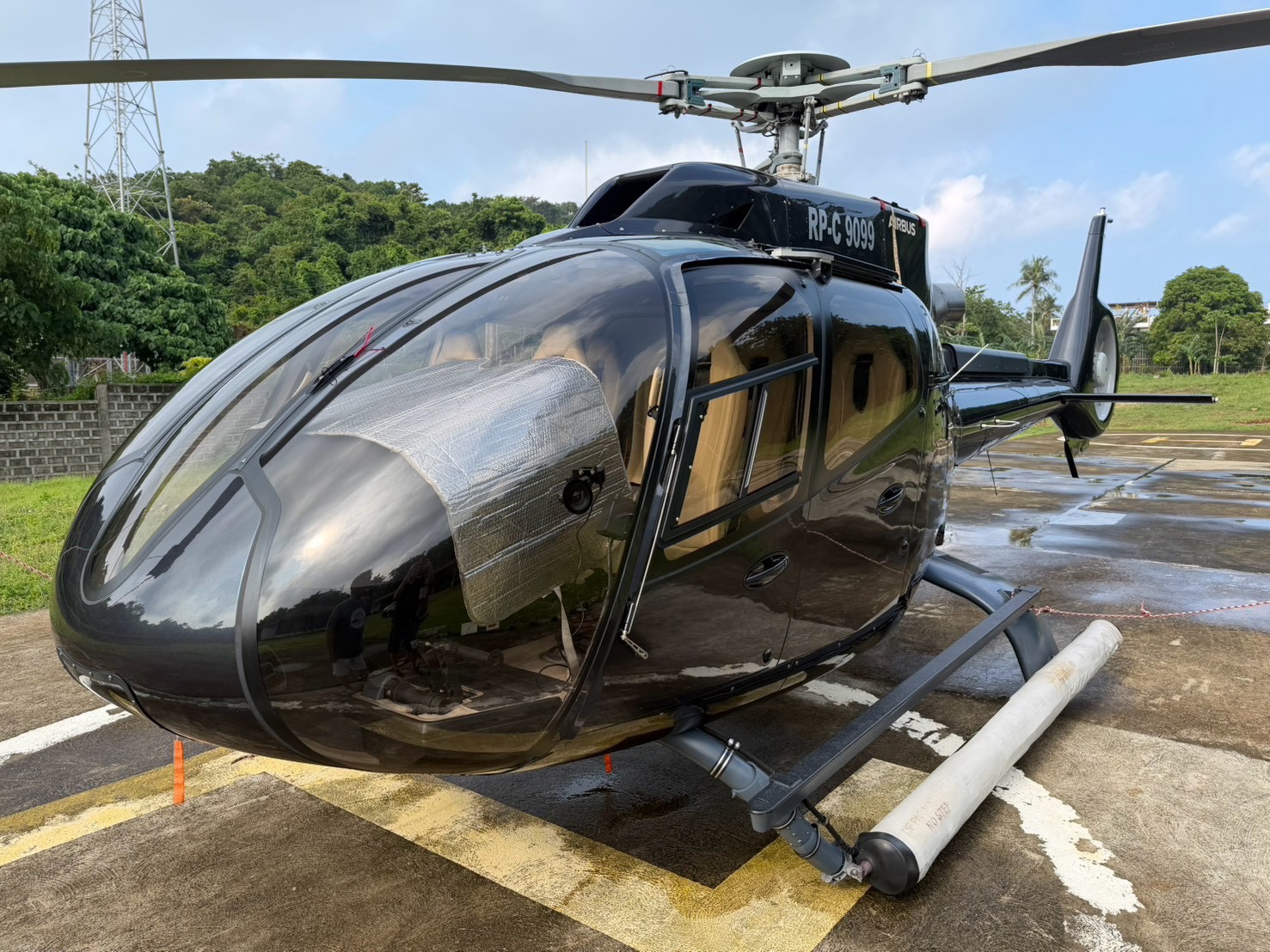 A black Airbus helicopter on the arrival pad